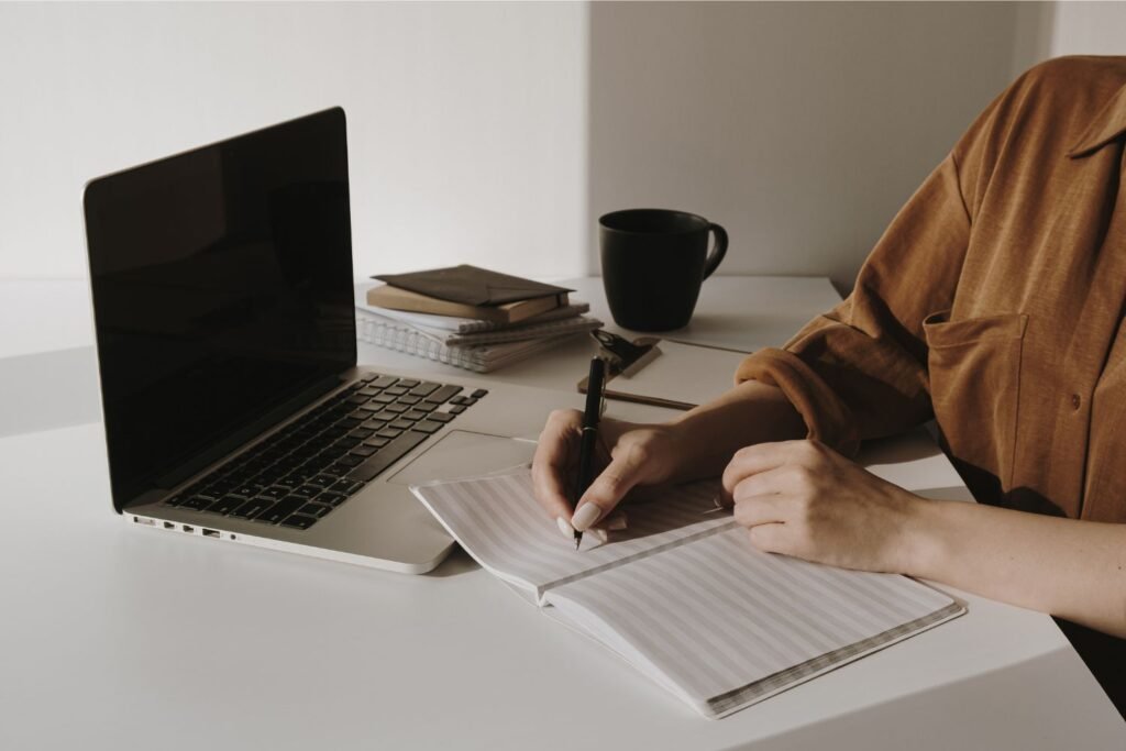 Eine Person sitzt am Schreibtisch vor einem Laptop und nimmt an einem digitalen Workshop teil